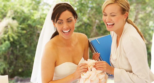 Bride laughing together with wedding planner.
